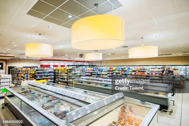 large, modern supermarket with freezers and shelving - supermarket fridge stock pictures, royalty-free photos & images