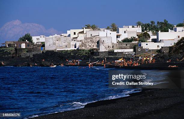 black volcanic sand and white washed buildings on beach. - aeolian islands 個照片及圖片檔