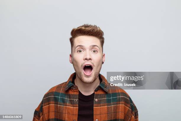 surprised young man looking at camera - man earring stock pictures, royalty-free photos & images