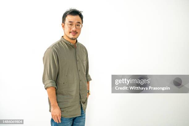 handsome young man in casual shirt and glasses standing isolated - asian man studio shot photos et images de collection