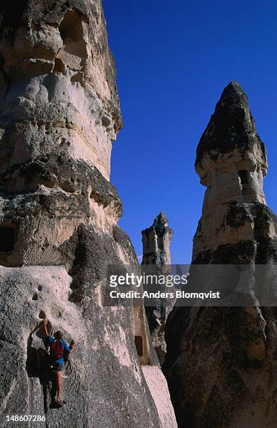 a tourist climbs around a phallic shaped rock to get to an abandoned dwelling. - forma de falo fotografías e imágenes de stock
