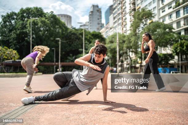 young man dancing with friends outdoors - bboy clothing stock pictures, royalty-free photos & images