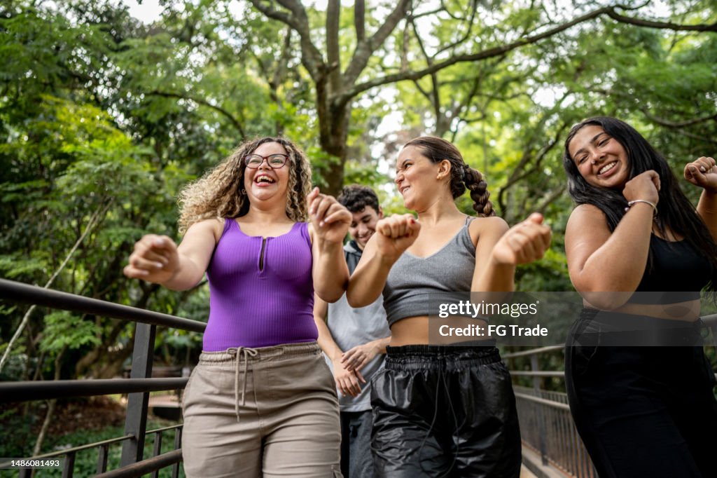 Friends walking and dancing in the park