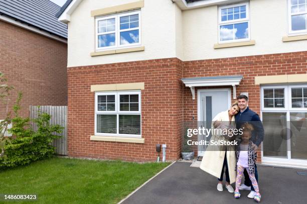 happy family in front of their home - facing front stock pictures, royalty-free photos & images