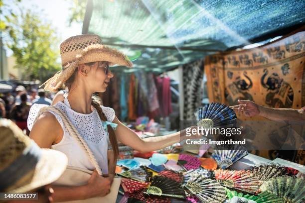 teenage girl buying souvenirs on flea market in andalusia, spain - souvenir bildbanksfoton och bilder