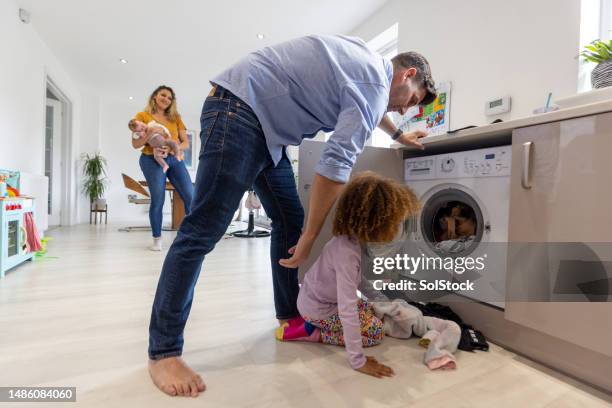 helping hand with the washing machine - afro man washing stock pictures, royalty-free photos & images