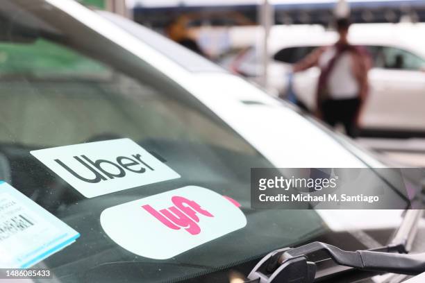 Lyft decal is seen on a car in the pick-up area at JFK Airport on April 28, 2023 in New York City. Lyft, the ride-hailing app, confirmed that it will...