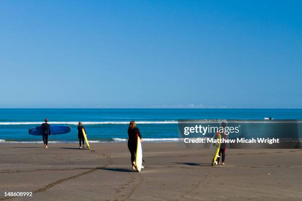 raglan surf shool and mojo surf school instructers give their surf students pointers on how to improve. - mojo stock pictures, royalty-free photos & images