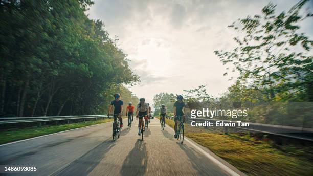 asiatisches chinesisches radfahrerteam, das am wochenendmorgen in ländlicher gegend radelt, von hinten beleuchtetes warmes licht - straßenradsport stock-fotos und bilder