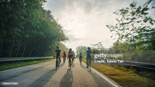 squadra di ciclisti asiatici cinesi in bicicletta nella zona rurale durante la luce calda retroilluminata del fine settimana mattina - ciclismo gruppo foto e immagini stock