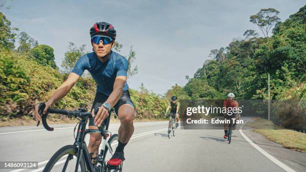 asiatischer chinesischer männlicher radfahrer, der bergab fährt und das radfahren am wochenende in der ländlichen szene genießt - cycling event stock-fotos und bilder