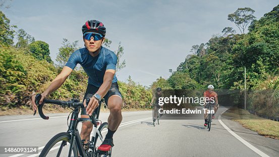 Asian Chinese male cyclist cruising downhill enjoying weekend cycling at rural scene Asian Chinese male cyclist cruising downhill enjoying weekend cycling at rural scene