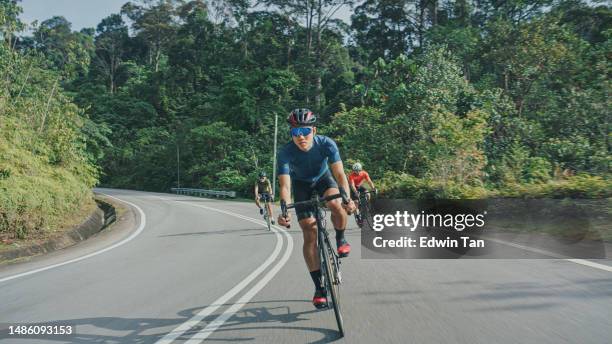 ciclista masculino asiático chino navegando cuesta abajo disfrutando del ciclismo de fin de semana en la escena rural - pelotón términos deportivos fotografías e imágenes de stock