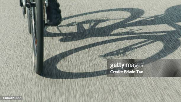 ciclistas chinos asiáticos de ángulo bajo pedaleando cuesta arriba en una zona rural durante la mañana del fin de semana - pelotón términos deportivos fotografías e imágenes de stock