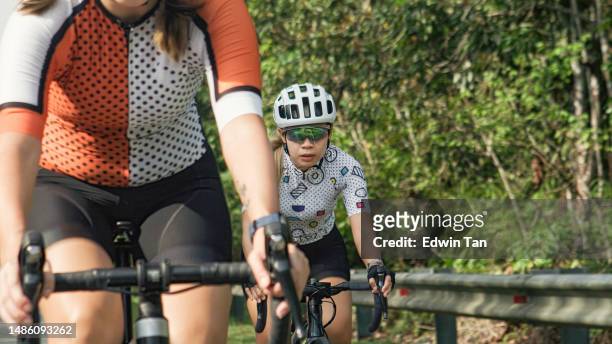 asian chinese female cyclist catching up in cycling competition in rural scene - race leader athlete stock pictures, royalty-free photos & images