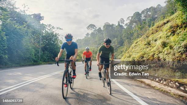 ciclista masculino asiático chino navegando cuesta abajo disfrutando del ciclismo de fin de semana en la escena rural - pelotón fotografías e imágenes de stock