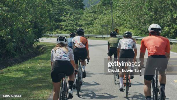 rear view asian chinese cyclist leader leading team cycling in rural area during weekend morning - cycling shorts stock pictures, royalty-free photos & images
