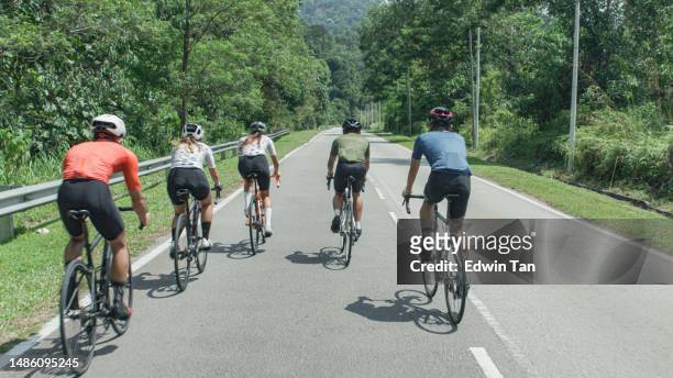 週末の朝、農村部でサイクリングを通り過ぎるアジア系中国人サイクリストチームの背面図 - 自転車競技大会 ストックフォトと画像