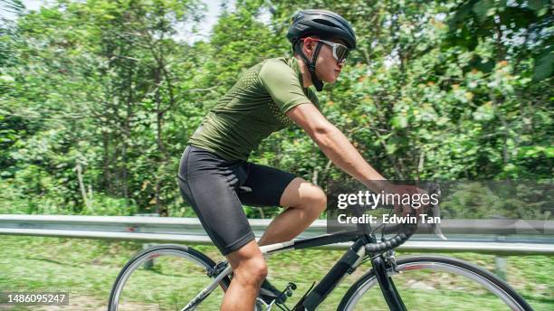 asian chinese cyclist side view cycling in rural scene under hot sun - wielrennerskleren stockfoto's en -beelden