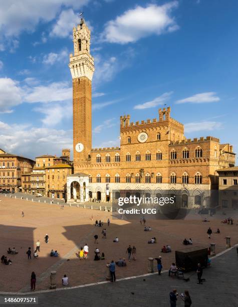 Siena, Siena Province, Tuscany, Italy. The Palazzo Pubblico with the Torre de Mangia seen across the Piazza del Campo. The historic center of Siena...