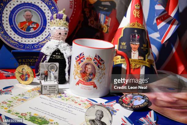 In this photo illustration, a selection of souvenirs to mark the Coronation of King Charles III, including 00 Gauge model railway figures, replica...