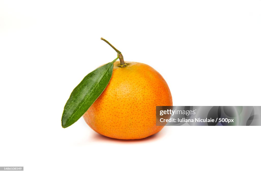 Fresh tangerine with green leaf isolated on white background
