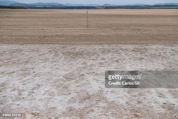 Level meter stuck into the ground of the dry Fuente de Piedra lagoon on April 28, 2023 in Fuente de Piedra, Spain. Due to the lack of rainfall and...
