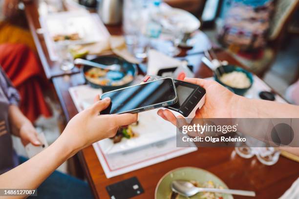mobile nfc payment in cafe, no cash. cropped woman hand using smartphone for contactless payment in cafe - comunicação por campo de proximidade - fotografias e filmes do acervo
