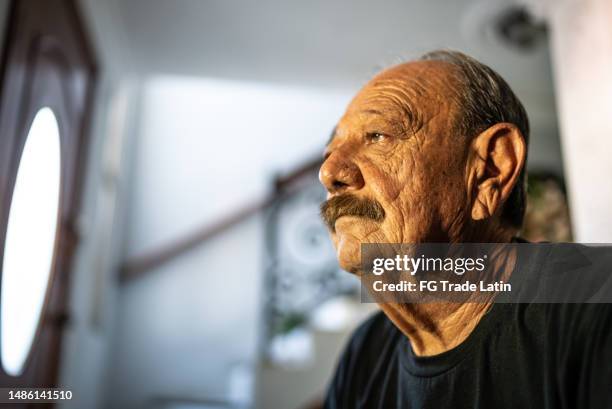 senior man worried looking away at home - low self esteem stock pictures, royalty-free photos & images