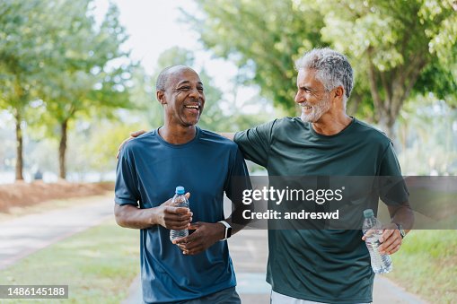 Senior friends walking in public park Senior friends walking in public park