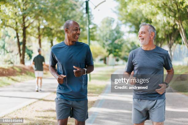 deux amis qui courent dans le parc public - black and white photo out door sport photos et images de collection