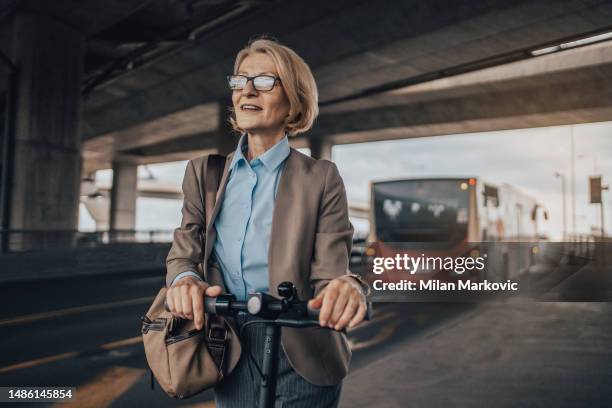 a mature businesswoman is waiting for public transport - 50 metros 個照片及圖片檔