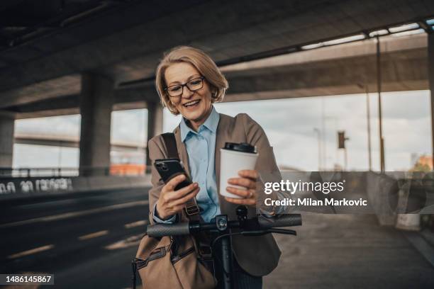 a mature businesswoman is waiting for public transport - 50 metros 個照片及圖片檔