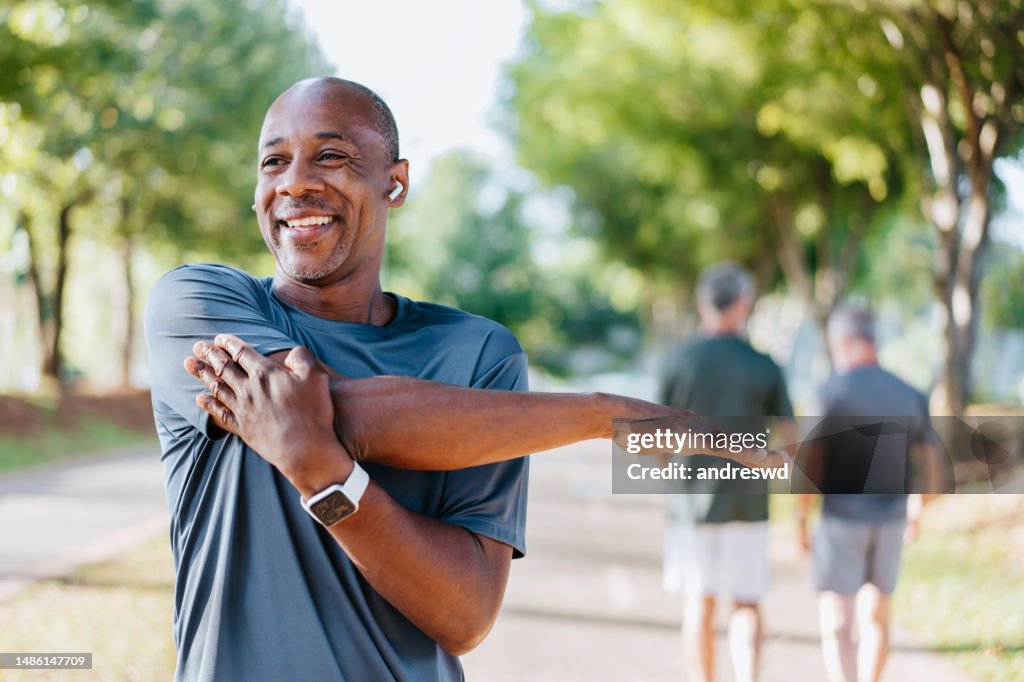 Portrait d’un homme mûr faisant des étirements dans un parc public