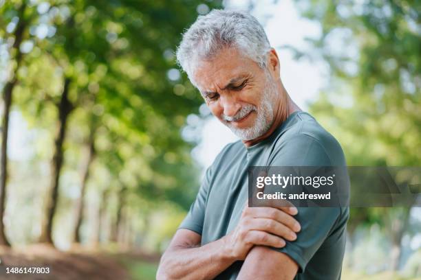 senior men with shoulder pain - pain imagens e fotografias de stock