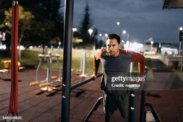 junger mann trainiert in open-air-fitnessstudio - open workouts stock-fotos und bilder