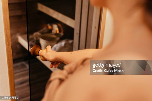 woman entering a sauna at home. - sauna stock-fotos und bilder