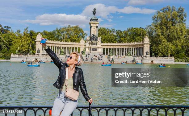 frau macht ein selfie im buen retiro park in madrid - madrid places to visit stock-fotos und bilder