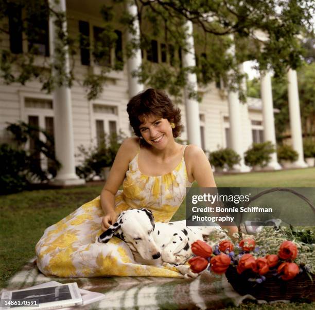 American actress Ally Sheedy smiles and poses with her dalmatian on her front lawn in Los Angeles, California, May 1986.