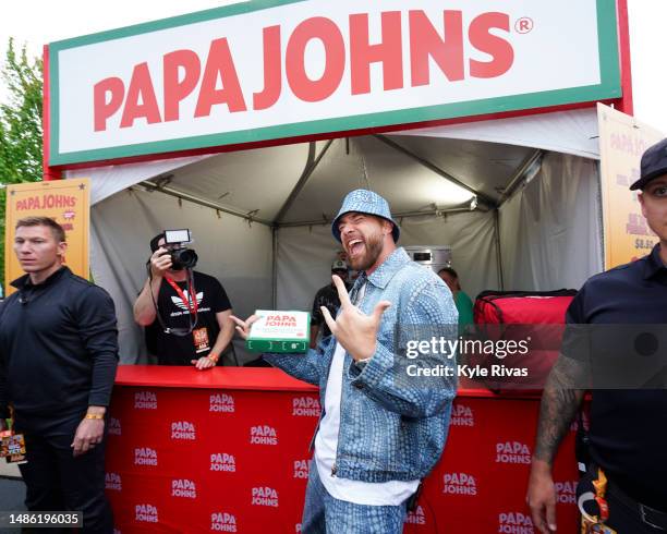 Travis Kelce of the Kansas City Chiefs samples pizza at a Papa Johns food stand during Kelce Jam at Azura Amphitheater on April 28, 2023 in Bonner...
