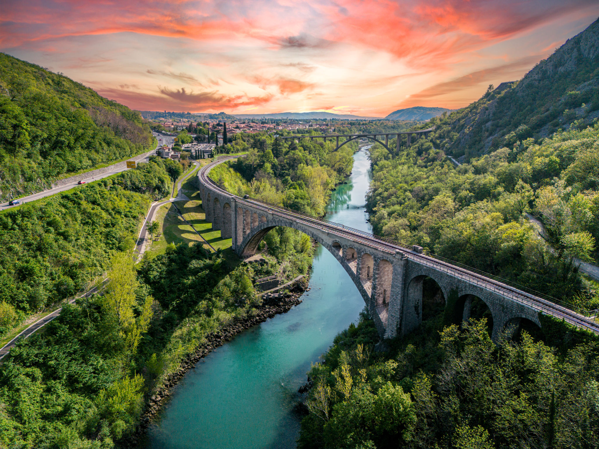 Amazing sunset view of a large stone railway bridge over beautiful green Soca river, aerial view in Slovenia Amazing sunset view of a large stone railway bridge over beautiful green Soca river, aerial view in Slovenia