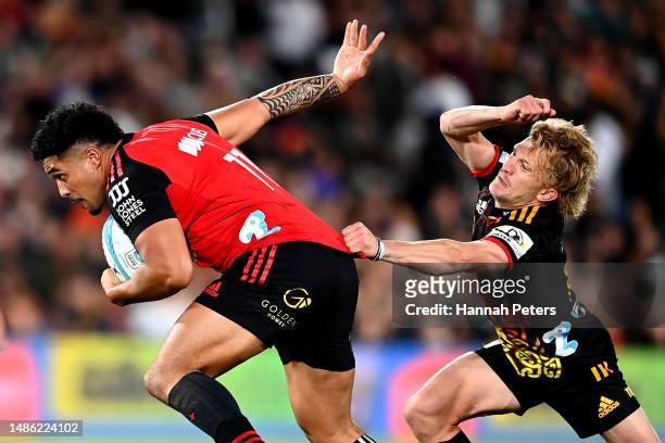 Leicester Fainga'anuku of the Crusaders evades Damian McKenzie of the Chiefs during the round 10 Super Rugby Pacific match between Chiefs and...