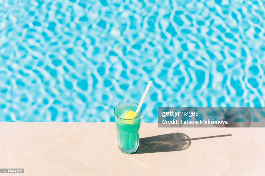 Blue lagoon cocktail at the edge of the blue pool.