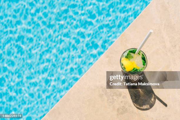 mojito cocktail on the edge of the blue pool. - schwimmbeckenrand stock-fotos und bilder