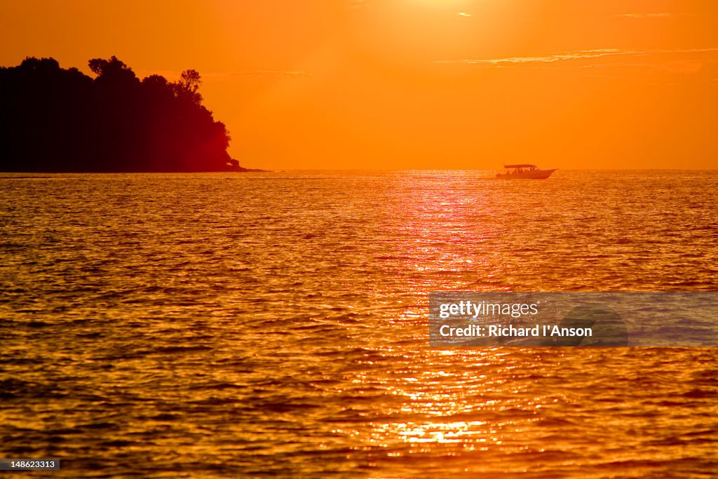 Boat on water at sunset.