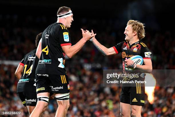Brodie Retallick celebrates with Damian McKenzie of the Chiefs after scoring a try during the round 10 Super Rugby Pacific match between Chiefs and...
