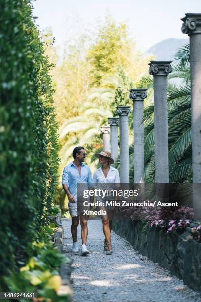 couple walk through city gardens together - person holding flowers with high energy stock-fotos und bilder