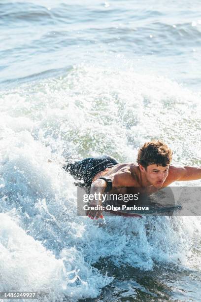 young man is having fun enjoying bodyboarding, boogie board - bodyboard surf imagens e fotografias de stock