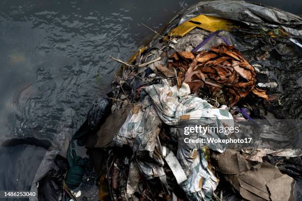 textile garbage in water - textile waste stock pictures, royalty-free photos & images