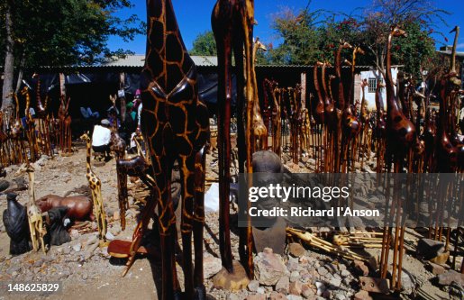 Carved wooden giraffes and stone sculptures for sale at a craft market at Victoria Falls Carved wooden giraffes and stone sculptures for sale at a craft market at Victoria Falls
